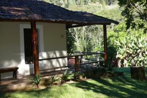 un pabellón de madera con un banco en un patio en Hotel Fazenda São Francisco, en Cunha