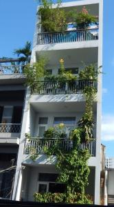 a tall white building with plants on the balconies at Homestay 37 AD in Ho Chi Minh City