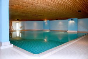 una gran piscina con suelo de baldosa y techo de madera en CENTRAL PENTHOUSE GREAT LAKE VIEW en St. Moritz