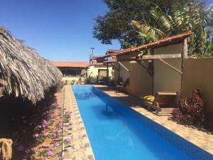 a swimming pool next to a house with a resort at Hospedagem Portal da Terra in São João