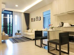 a kitchen and living room with a couch and a table at Navi Vt-ara36 Condo in Bangkok