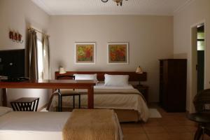 1 dormitorio con escritorio, 1 cama y escritorio en Hotel Fazenda São Francisco, en Cunha