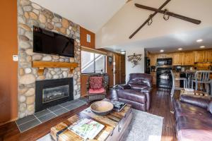 a living room with a stone wall with a fireplace at Red Pine Condominiums in Park City