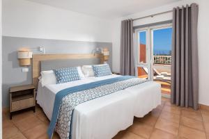 a bedroom with a large bed and a balcony at Sol Barbacan in Playa del Ingles