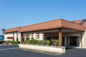 a building with a red roof in a parking lot at Days Inn by Wyndham Hillsborough in Hillsborough