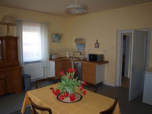 una cocina con una mesa con un jarrón de flores. en Ferienhaus Maria en Vinningen