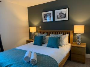 ウィンザーにあるFamily Apartments in Windsor with Twin Roomsのベッドルーム1室(青と白の枕が備わるベッド1台付)