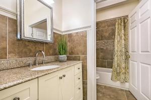 a bathroom with a sink and a mirror at Spacious 4BR City Condo steps from St Charles Ave in New Orleans +24 photos