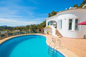 a villa with a swimming pool in front of a house at Casa Infinidad in Moraira +32 photos