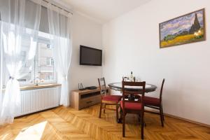een eetkamer met een tafel en stoelen en een raam bij Bridge Apartments 6 in Krakau