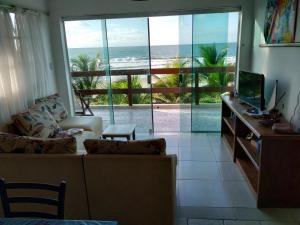 a living room with a view of the ocean at Apartamentos beira mar in Porto De Galinhas