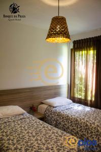 1 dormitorio con 2 camas y lámpara de araña en Bosque da Praia Flats en Pipa
