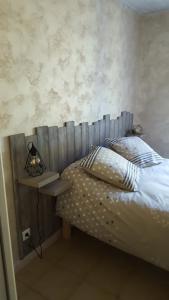 a bedroom with a bed with a wooden head board at Chez Alexandra in Louchats