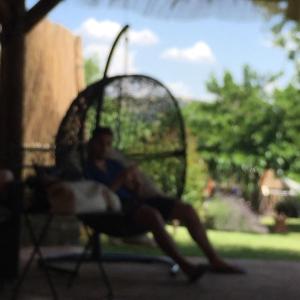 馬焦內的住宿－阿斯恩達農家樂一號特樂卡薩利公寓，坐在院子里椅子上的男人