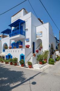 納克索喬拉的住宿－安東尼公寓，白色的建筑,有蓝色的门和盆栽植物