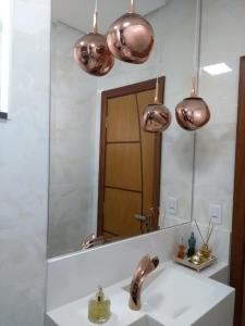 a bathroom with a sink and a mirror at Casa de Família in Capitólio
