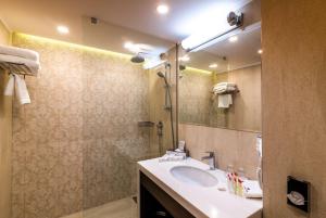 a bathroom with a sink and a mirror at Ramada Hotel & Suites by Wyndham Yerevan in Yerevan