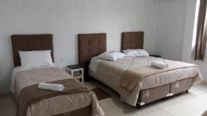 Un dormitorio con dos camas con toallas encima. en Pousada Campanário, en Cambará