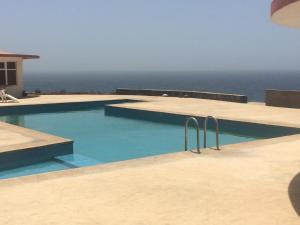 a swimming pool with the ocean in the background at Questel BronQ in Chã da Igreja