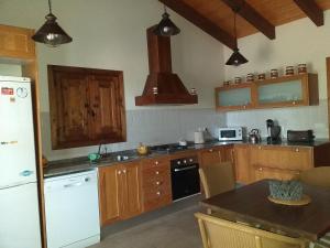 a kitchen with a refrigerator and a table with chairs at Mas dels Bonos in Deltebre