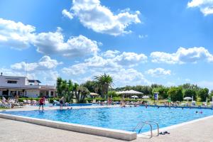 a pool at a resort with people in it at B&B Canneto Beach in Leporano