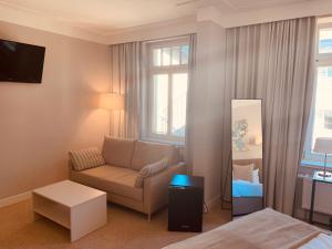 a living room with a couch and a mirror at Lindenau Inn in Leipzig