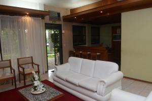 uma sala de estar com um sofá branco e uma mesa em River Hotel em Uruguaiana