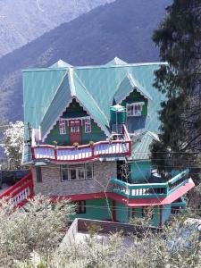 una casa con techo verde y techo verde en Hidden Woods Homestay en Darjeeling
