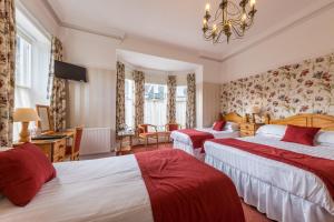 Habitación de hotel con 2 camas y lámpara de araña. en Dorchester House, en Keswick