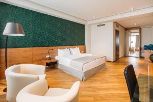 Habitación de hotel con cama, mesa y sillas en Hotel Tbilisi Tower en Tiflis