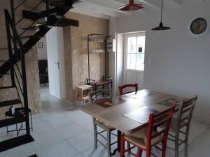 Un comedor con mesa y sillas de madera. en La Cour Carrée - Maisons de charme entre Blois et Chambord, en Montlivault 4 fotos más