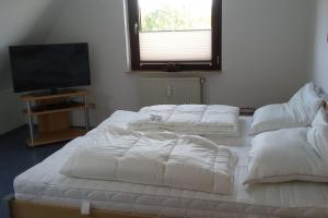 two large white beds in a room with a television at Gästewohnung von Oesen in Osterholz-Scharmbeck