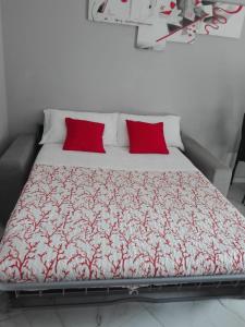 Bett mit roten Kissen in einem Zimmer in der Unterkunft Ylli home Sanremo in Sanremo