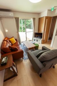 un soggiorno con divano e tavolo di Kunigami-gun - House / Vacation STAY 47786 a Onna