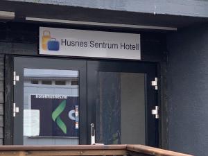 a sign above a glass door of a building at Husnes Sentrum Hotell in Husnes