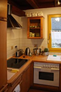 eine Küche mit einem Herd oberer Ofen neben einem Fenster in der Unterkunft Gut Müllerleile in Gengenbach