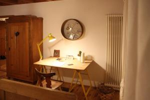 einen Schreibtisch in einem Zimmer mit einer Uhr an der Wand in der Unterkunft Gut Müllerleile in Gengenbach