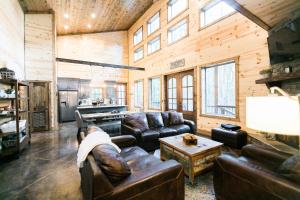 - un salon avec des canapés en cuir et une table dans l'établissement Fireside Creek Luxury Cabin, à Stephens Gap