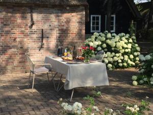 una mesa con comida y flores junto a una pared de ladrillo en Hof van Eersel en Eersel