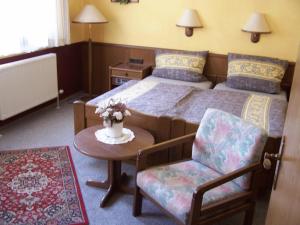 a bedroom with a bed and a chair and a table at Hotel Glindenberger Hof in Glindenberg +42 photos