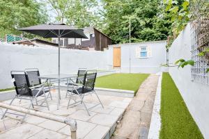 a patio with a table and chairs and an umbrella at Wow, what a space, check this out! in Swansea