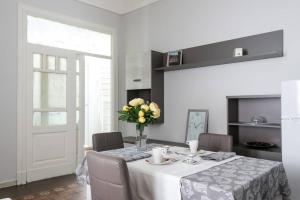 - une table à manger avec un vase de fleurs dans l'établissement Gramignani House Catania, à Catane