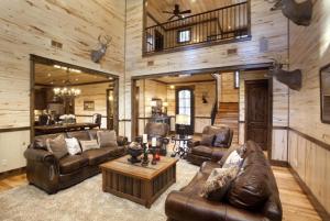 a living room with leather furniture in a cabin at Call It A Day Luxury Cabin in Stephens Gap