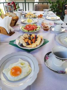 een lange tafel met borden eten en kopjes koffie bij Guest House Baba Lluka in Berat