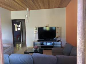 ein Wohnzimmer mit einem Sofa und einem Flachbild-TV in der Unterkunft Village do Capão in Vale do Capao