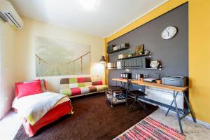 a bedroom with a bed and a desk with a clock at warm cozy & quiet in Athens