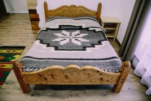 - un lit en bois avec une couverture dans l'établissement Котедж "Солард", à Yaremtche