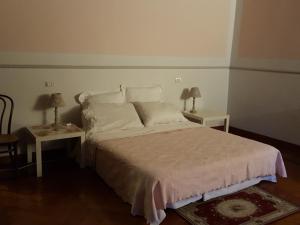 sypialnia z dużym łóżkiem z dwoma stołami w obiekcie Villa Ghia w mieście Parma