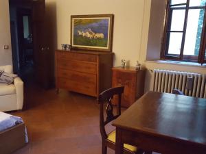 a living room with a table and a dresser with a picture of horses at Villa Ghia in Parma