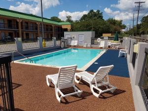 a swimming pool with two chairs and a swimming pool at Quality Inn in Alexandria